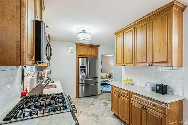 a kitchen with stainless steel appliances a stove a sink and a refrigerator