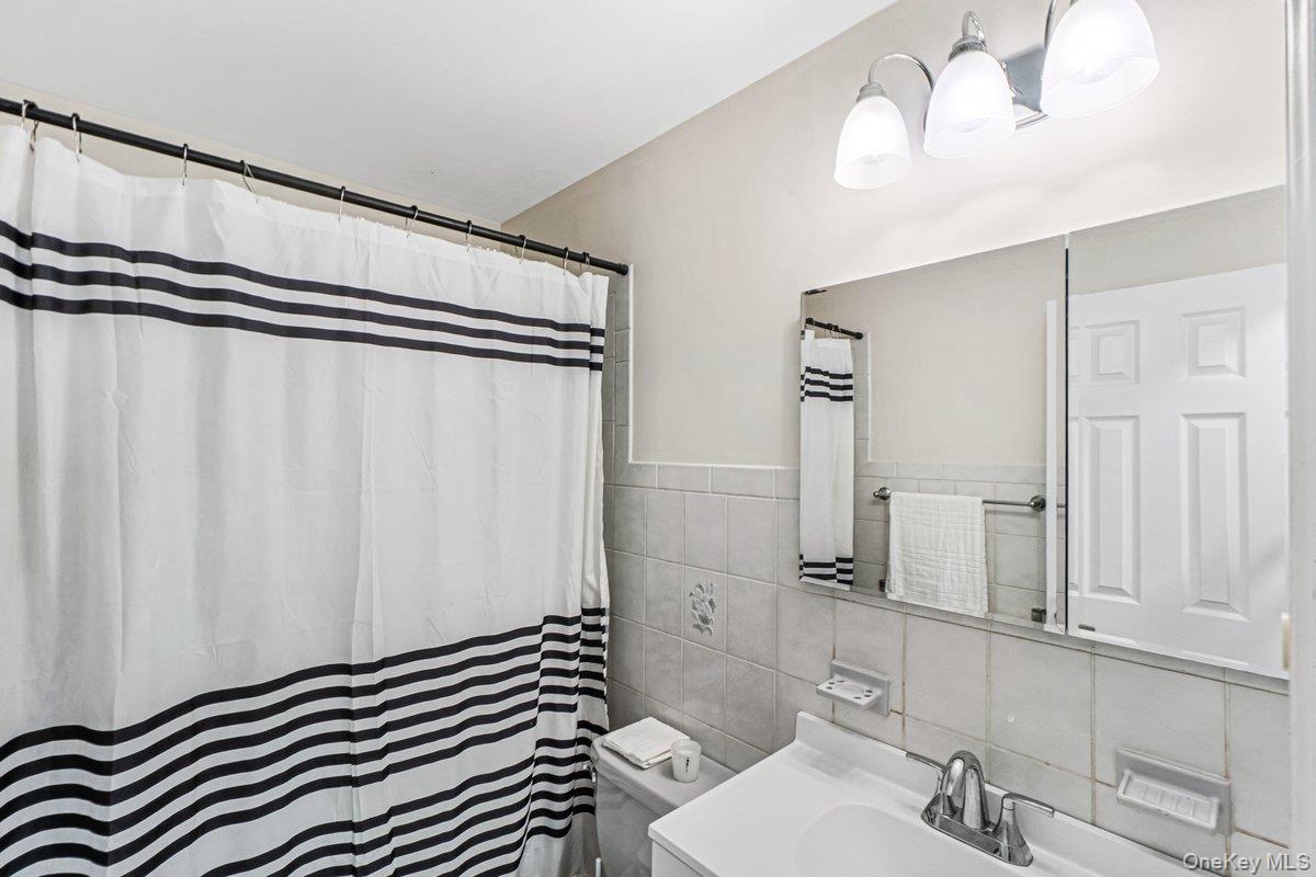 5 Terry Lane Plainview, NY 11803 - Photo 10 of 29 a bathroom with a sink a mirror and a shower