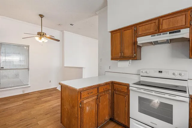 a kitchen with stainless steel appliances granite countertop a sink a stove oven a counter space and cabinets