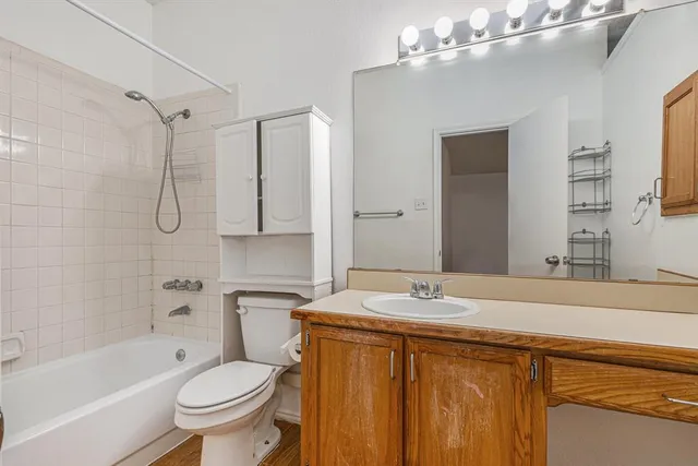 a bathroom with a granite countertop sink toilet and shower