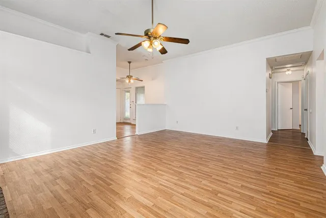 a view of empty room with wooden floor