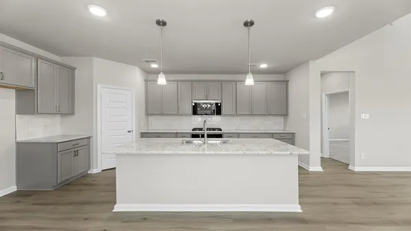 a kitchen with kitchen island a sink stainless steel appliances and wooden floor