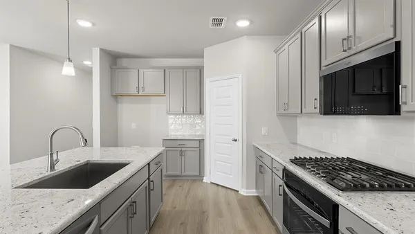 a kitchen with stainless steel appliances granite countertop a sink stove and refrigerator