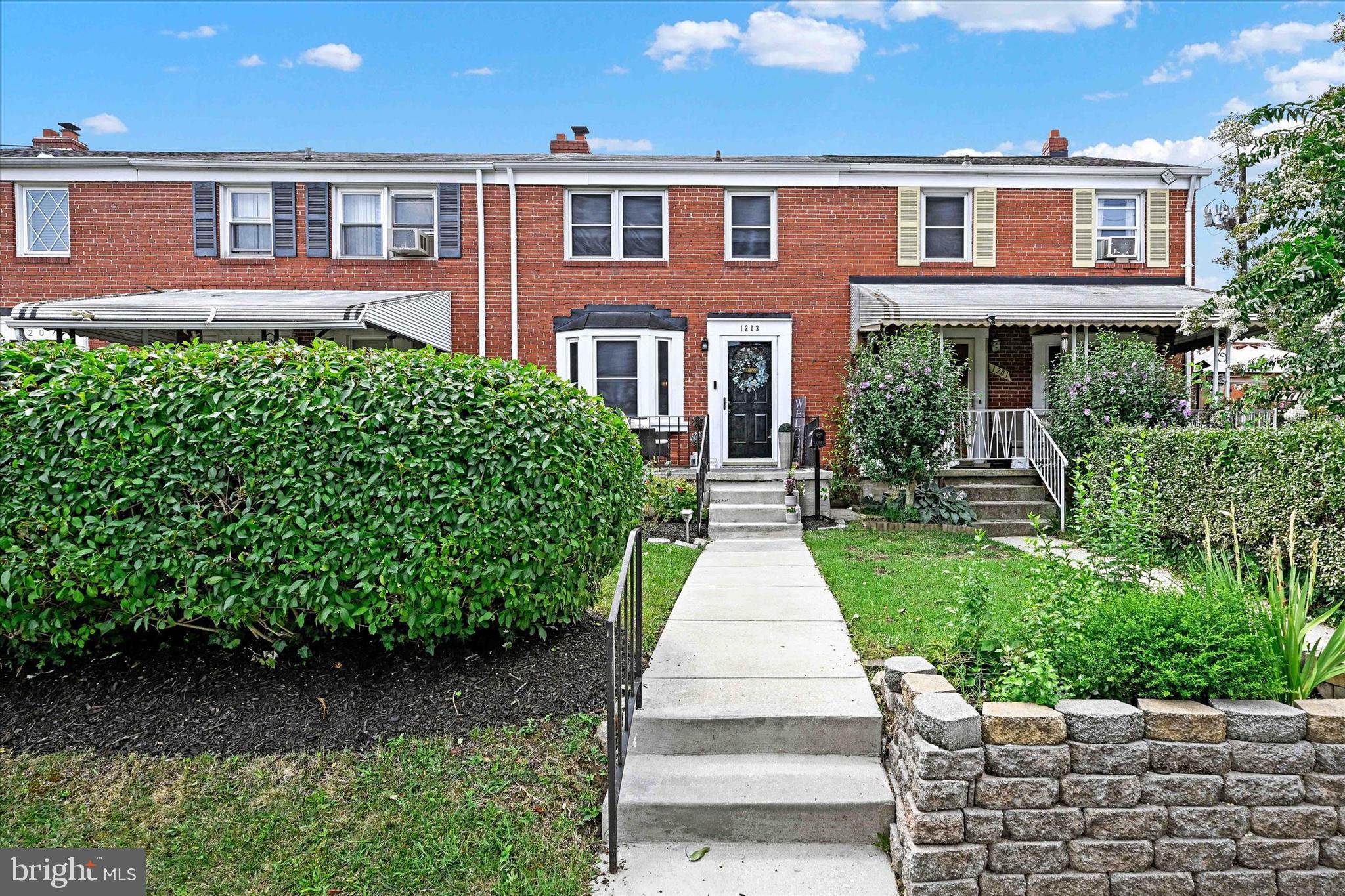1203 Walker Avenue Baltimore, MD 21239 - Photo 1 of 31 a front view of a house with a yard
