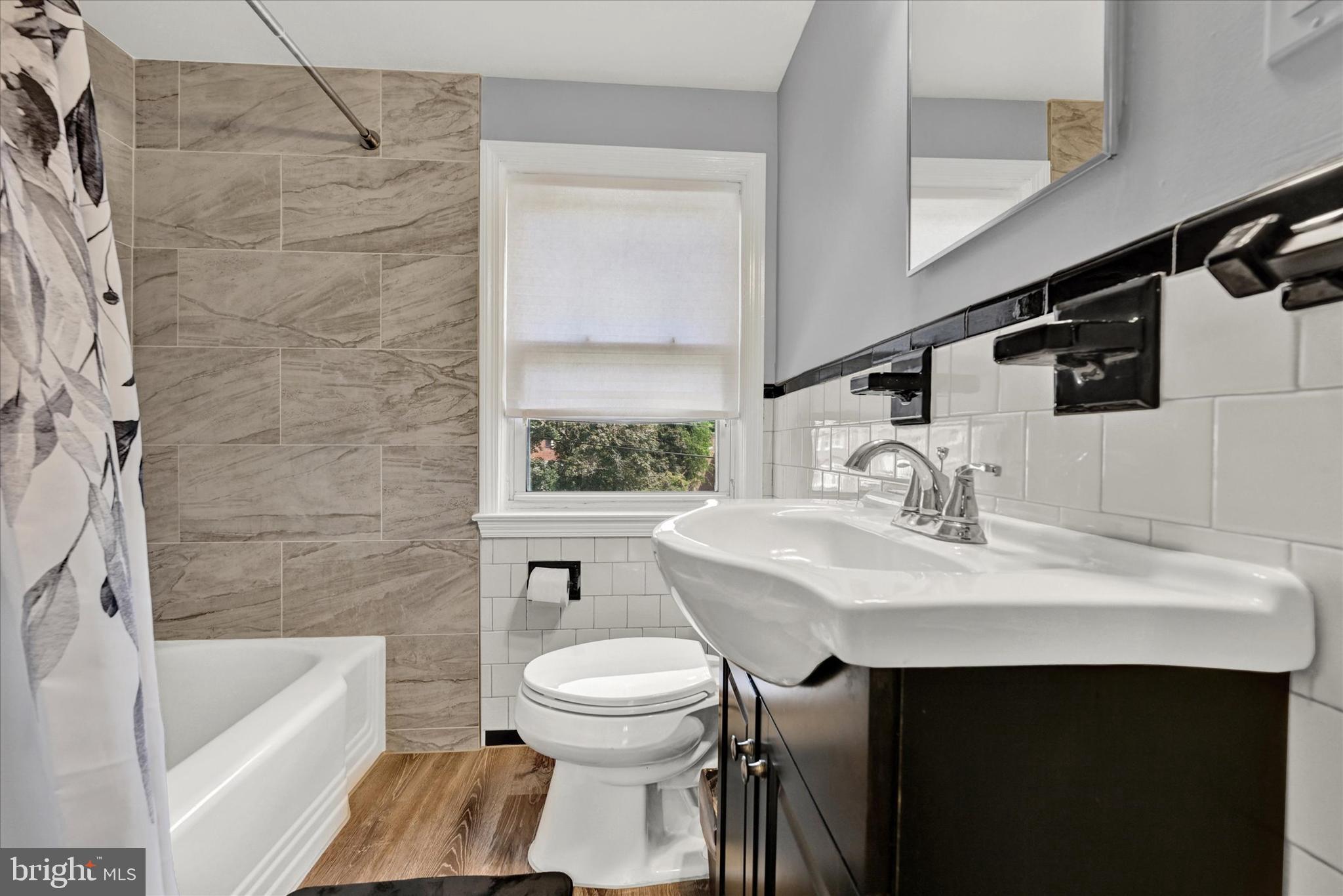 1203 Walker Avenue Baltimore, MD 21239 - Photo 14 of 31 a bathroom with a sink toilet a mirror and bathtub