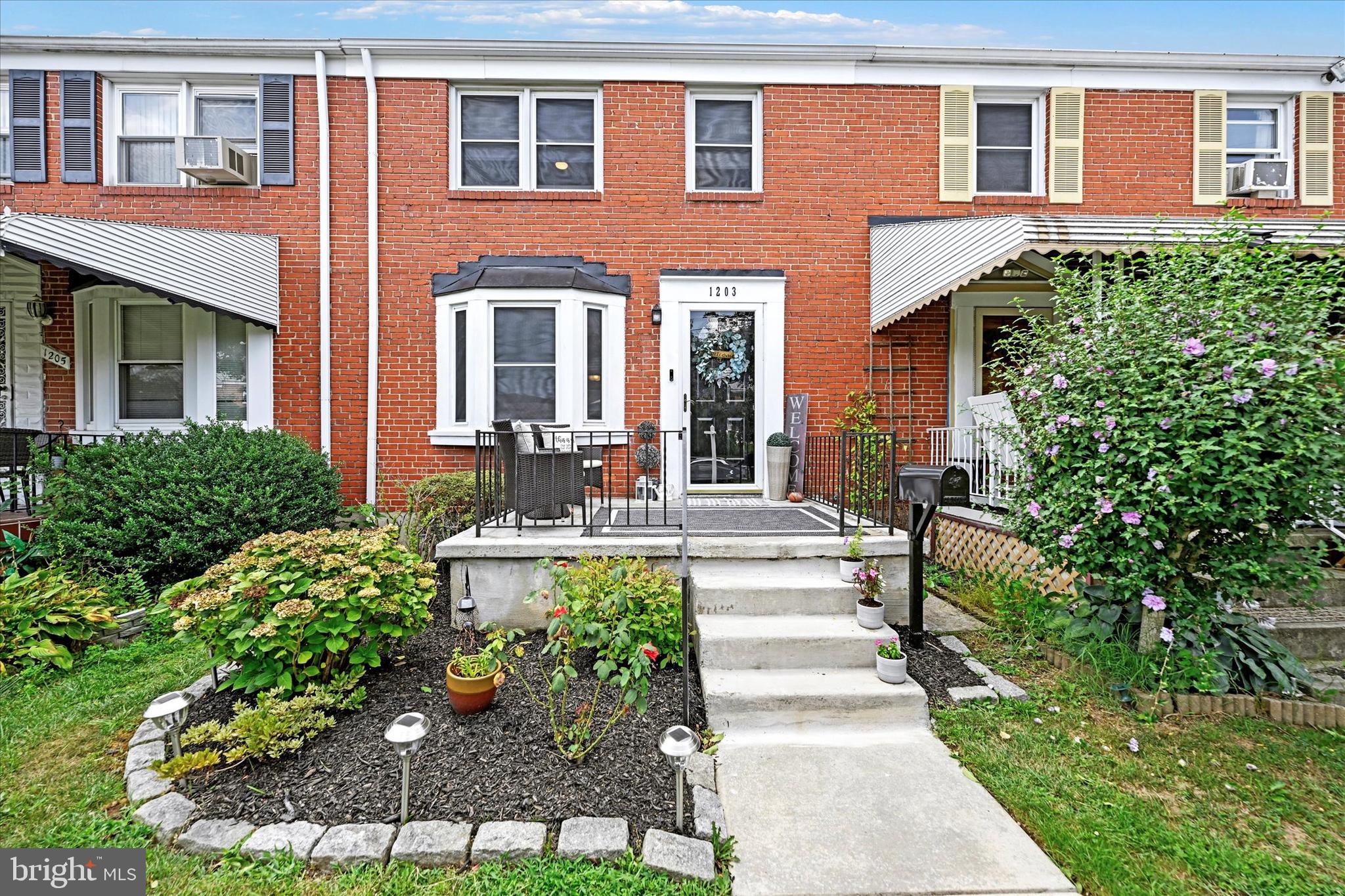 1203 Walker Avenue Baltimore, MD 21239 - Photo 2 of 31 a front view of a house with a yard and potted plants