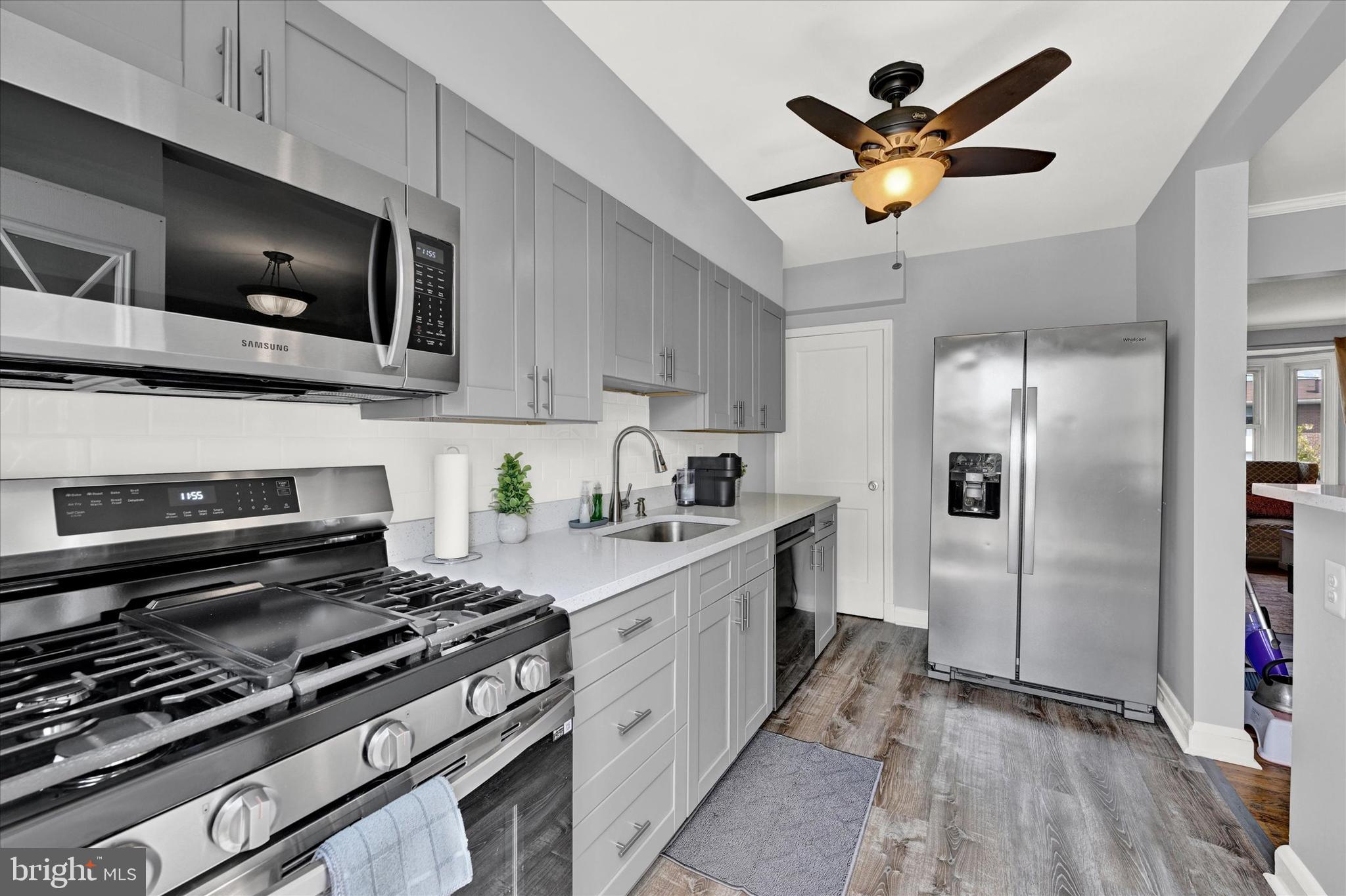 1203 Walker Avenue Baltimore, MD 21239 - Photo 9 of 31 a kitchen with stainless steel appliances a sink a stove oven a refrigerator with white cabinets and wooden floor