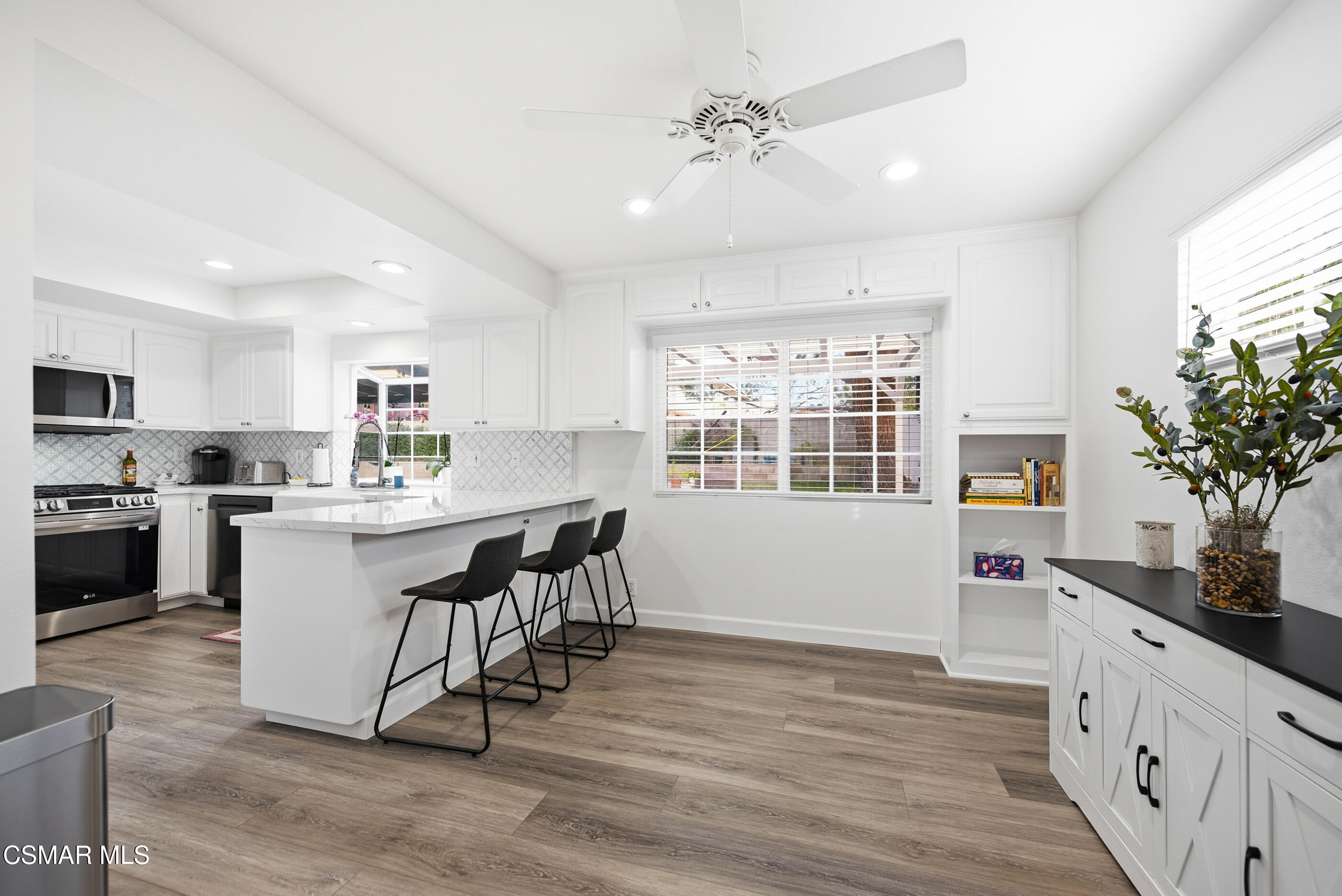 3598 Scofield Avenue Simi Valley, CA 93063 - Photo 14 of 86 a kitchen with a table chairs refrigerator and microwave