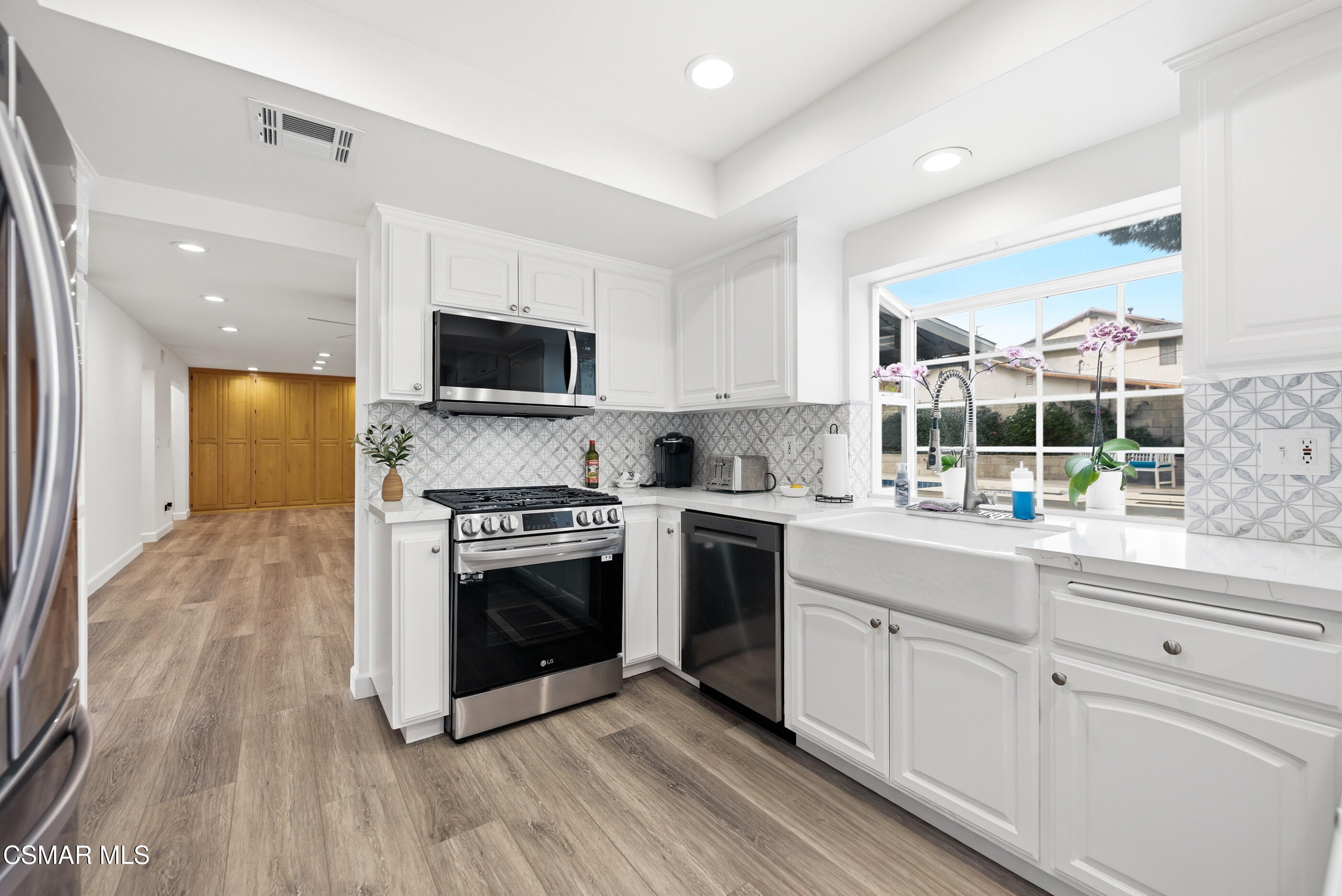 3598 Scofield Avenue Simi Valley, CA 93063 - Photo 20 of 86 a kitchen with stainless steel appliances white cabinets a sink and a stove