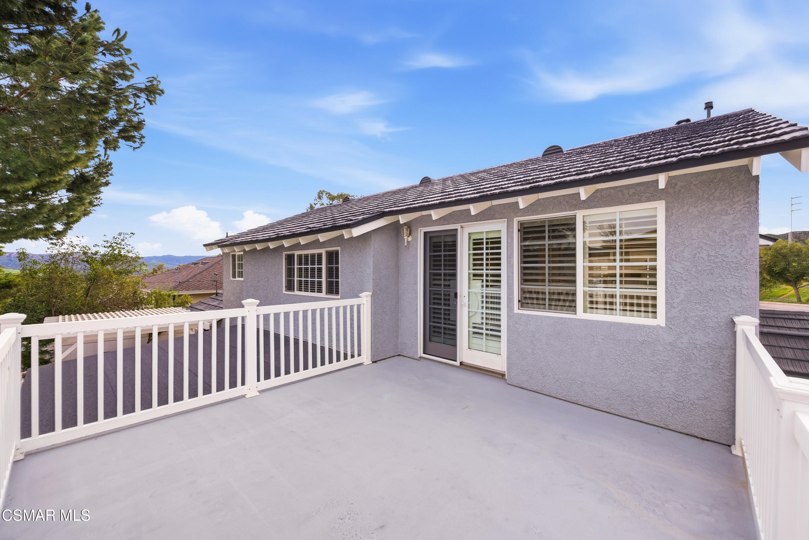 3598 Scofield Avenue Simi Valley, CA 93063 - Photo 46 of 86 a view of a house with a wooden deck and a floor to ceiling window
