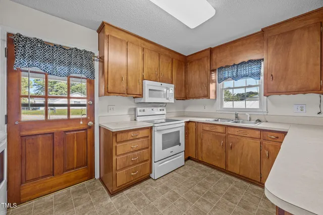 a kitchen with stainless steel appliances granite countertop wooden cabinets a sink and a stove