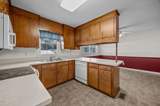 a kitchen with stainless steel appliances granite countertop a sink stove and cabinets