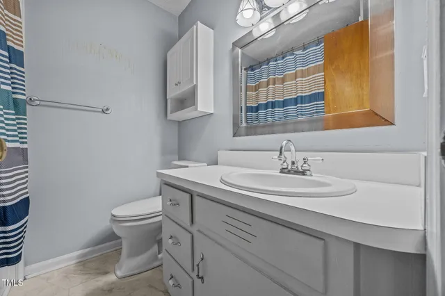 a bathroom with a sink toilet and mirror