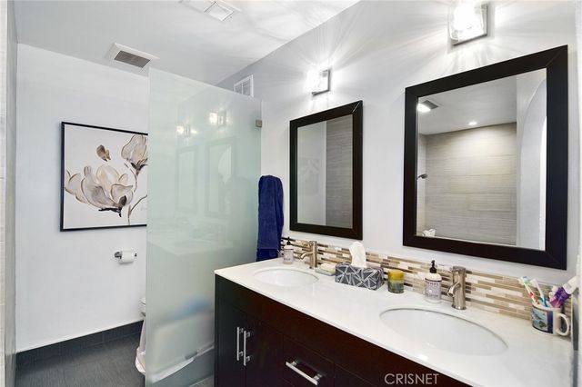 a bathroom with a double vanity sink and a mirror