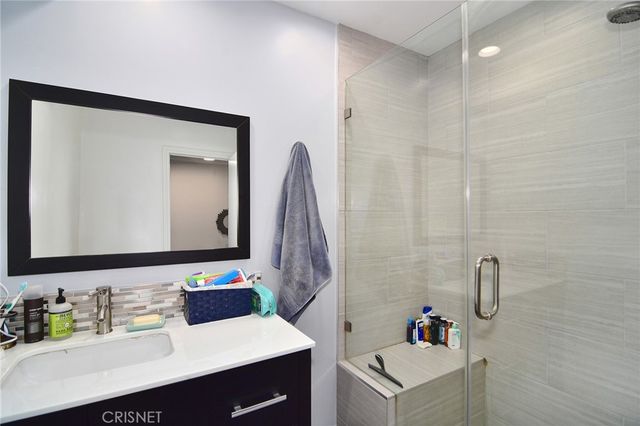 a bathroom with a sink vanity tub and a mirror