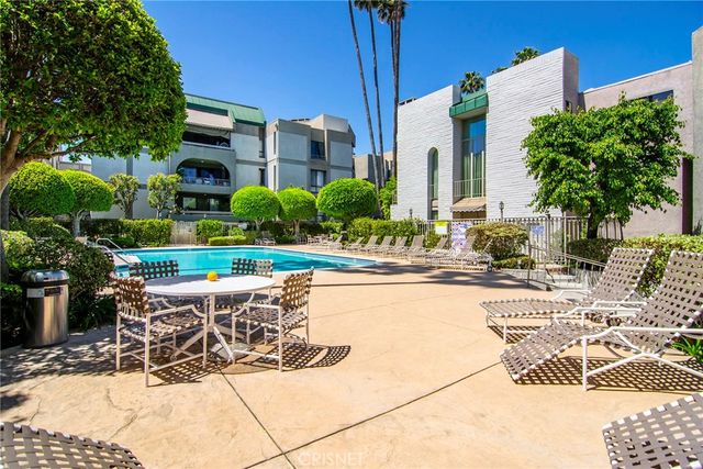 a view of a patio with couches and table and chairs and potted plants
