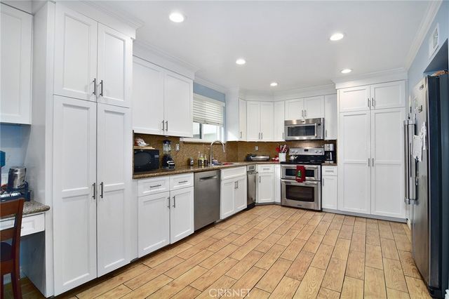 a kitchen with cabinets and wooden floor