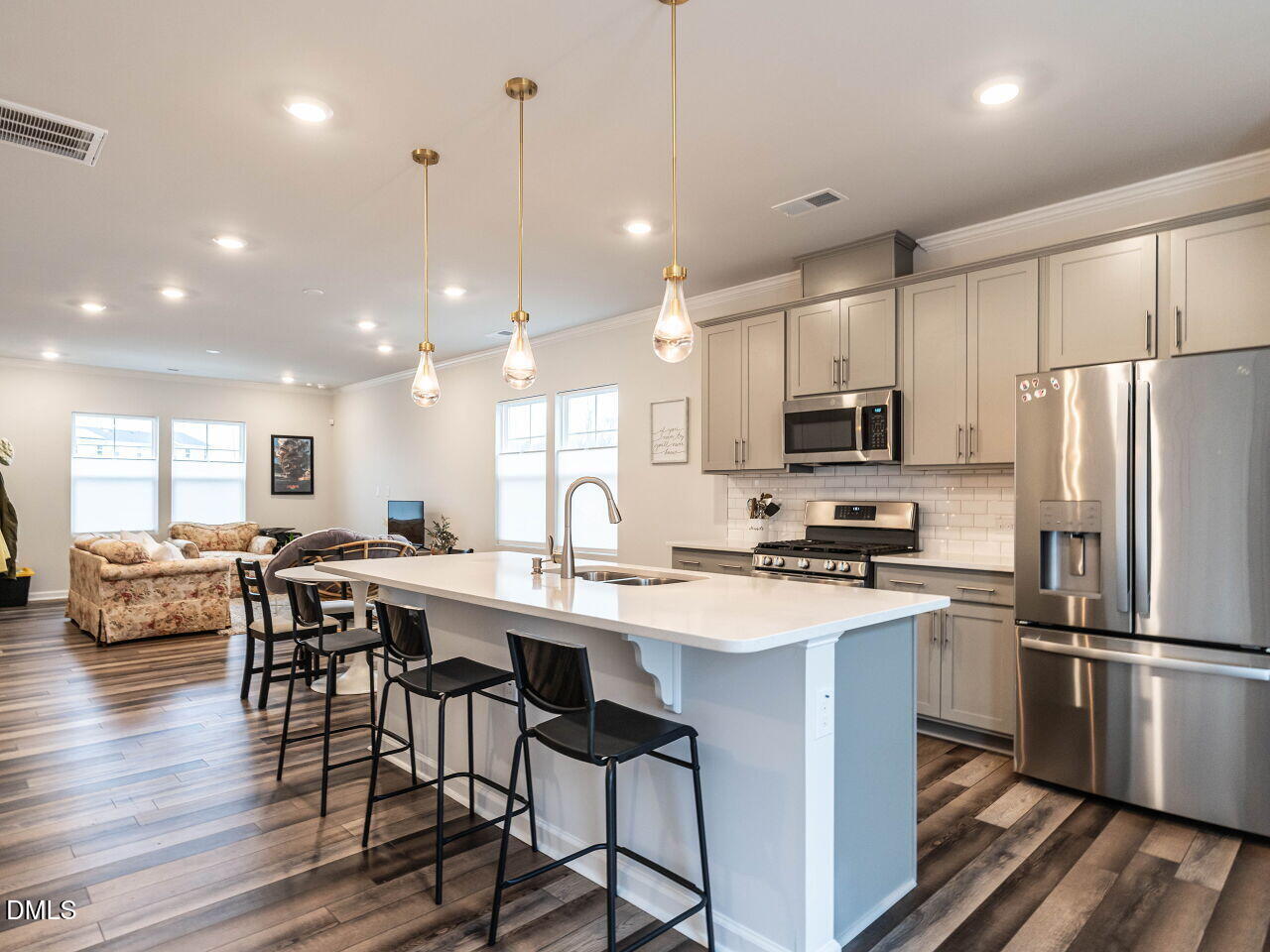 2456 Tonoloway Drive Raleigh, NC 27610 - Photo 17 of 45 a kitchen with stainless steel appliances a dining table chairs stove refrigerator and wooden floor