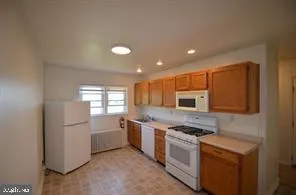 a kitchen with stainless steel appliances granite countertop a refrigerator a stove a sink and a microwave