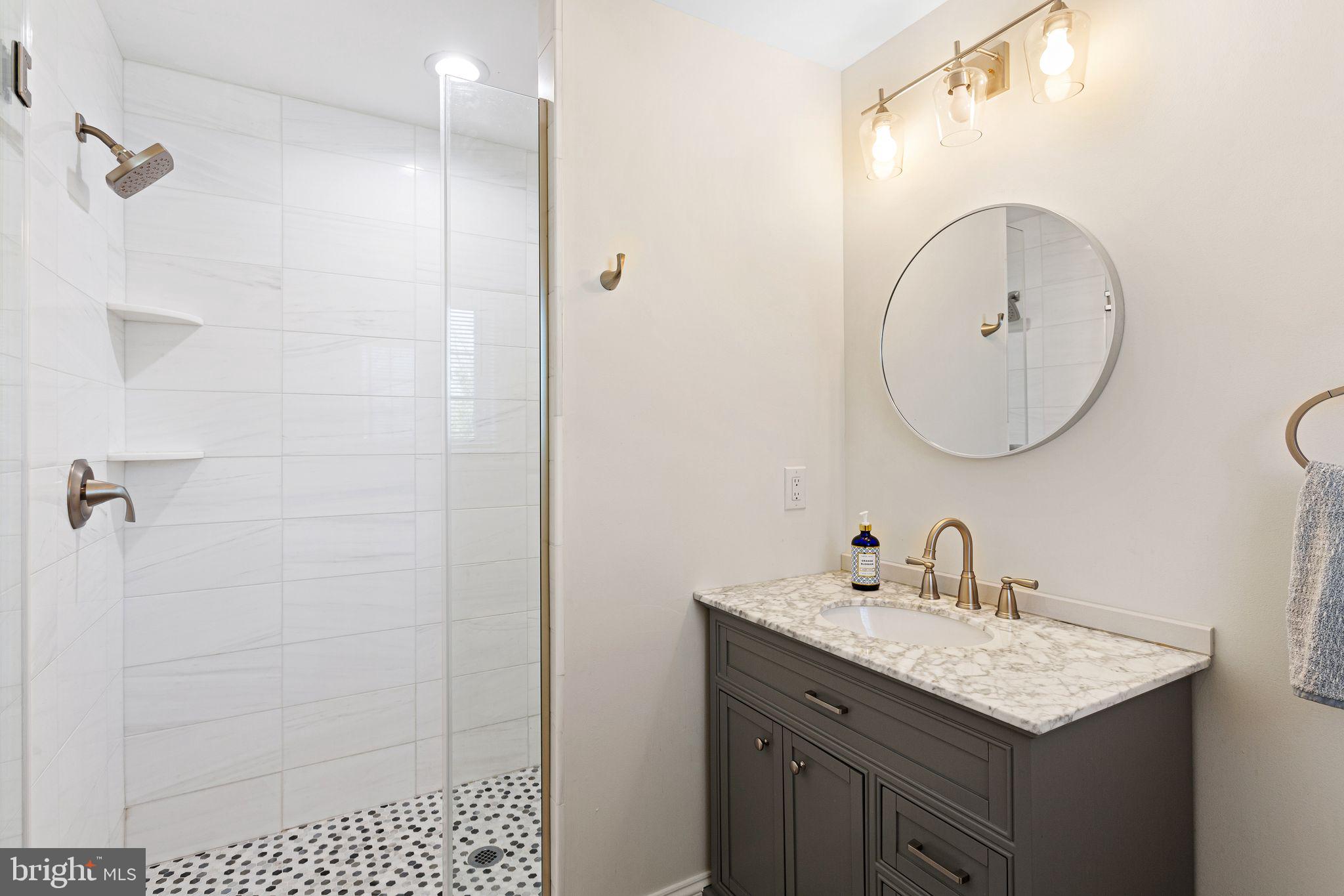 305 Grove Street Haddonfield, NJ 08033 - Photo 33 of 45 a bathroom with a granite countertop sink a mirror and shower