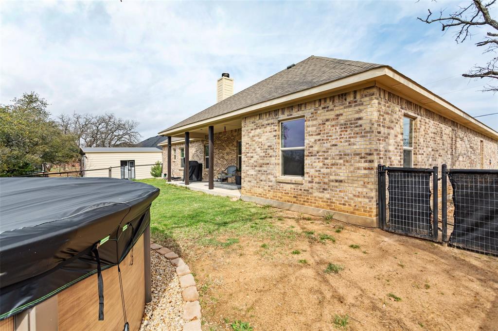 223 Cottongame Road Weatherford, TX 76088 - Photo 28 of 39 a backyard of a house with wooden floor table and chairs