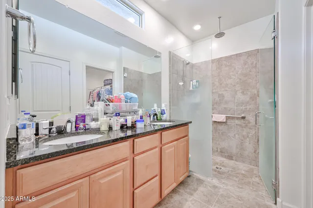 a bathroom with a double vanity sink mirror and shower