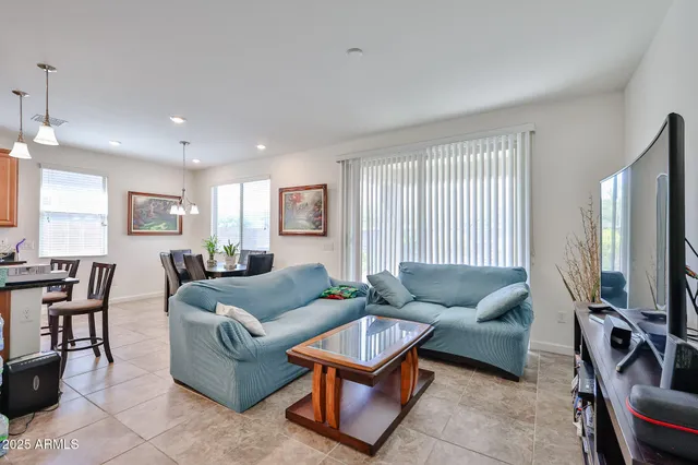 a living room with furniture a flat screen tv and a window