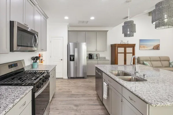 a kitchen with stainless steel appliances granite countertop a sink stove and refrigerator
