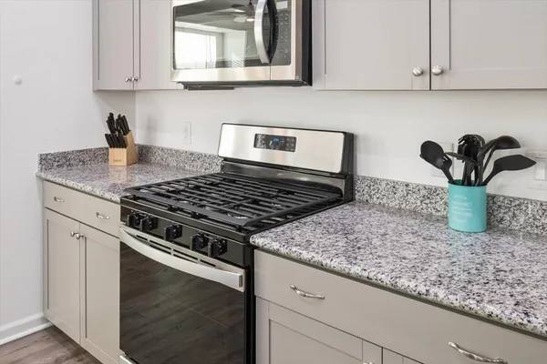 a kitchen with granite countertop stainless steel appliances and white cabinets