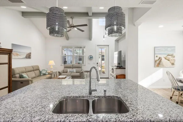 a kitchen with a sink a counter space and chandelier