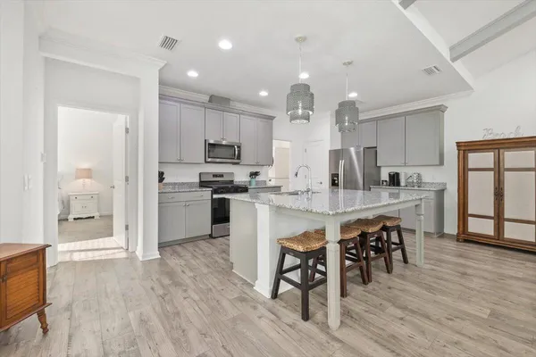 a kitchen with kitchen island a dining table chairs and wooden floor
