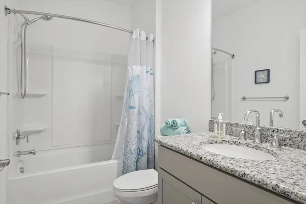 a bathroom with a granite countertop sink toilet and shower