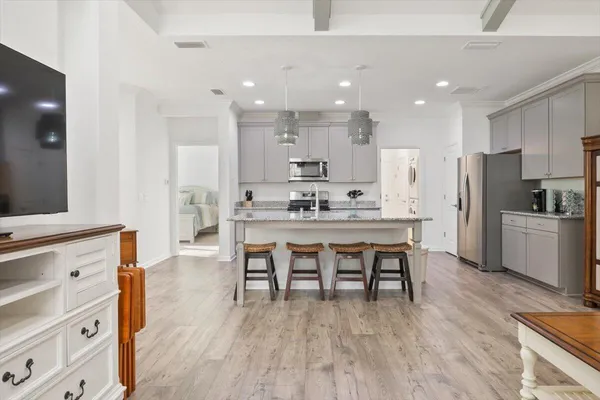a kitchen with kitchen island a white counter top space stainless steel appliances and cabinets
