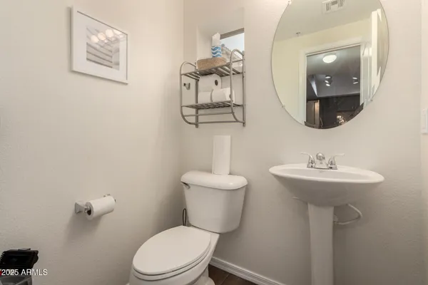 a bathroom with a toilet a sink and mirror