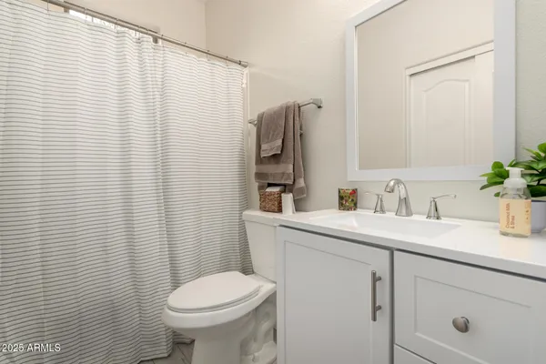 a bathroom with a sink a toilet and mirror