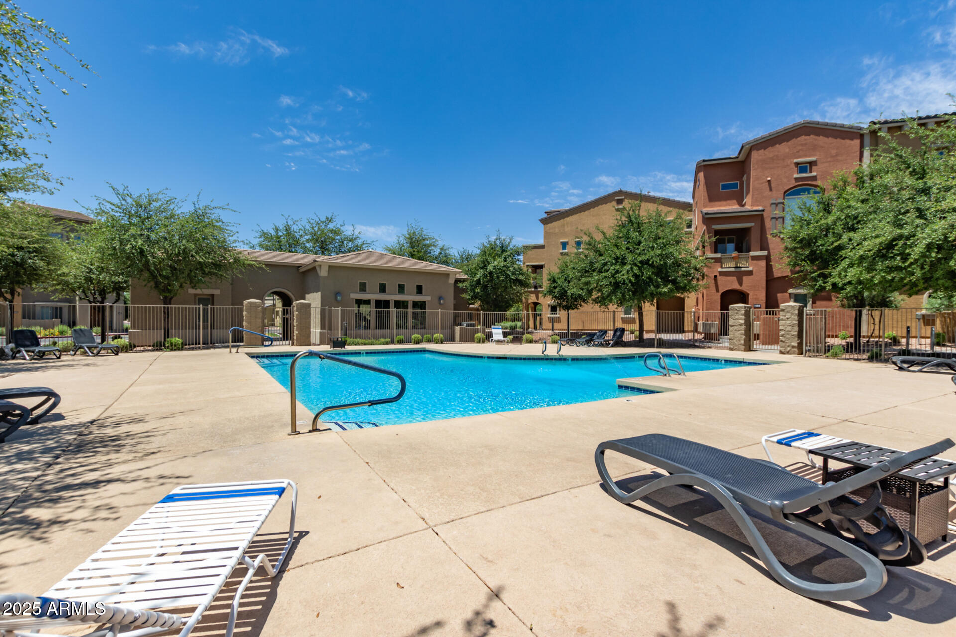 240 West Juniper Avenue, Unit 1010 Gilbert, AZ 85233 - Photo 46 of 46 a view of a swimming pool with a lounge chairs