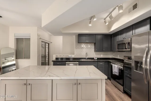a kitchen with a sink stainless steel appliances and white cabinets