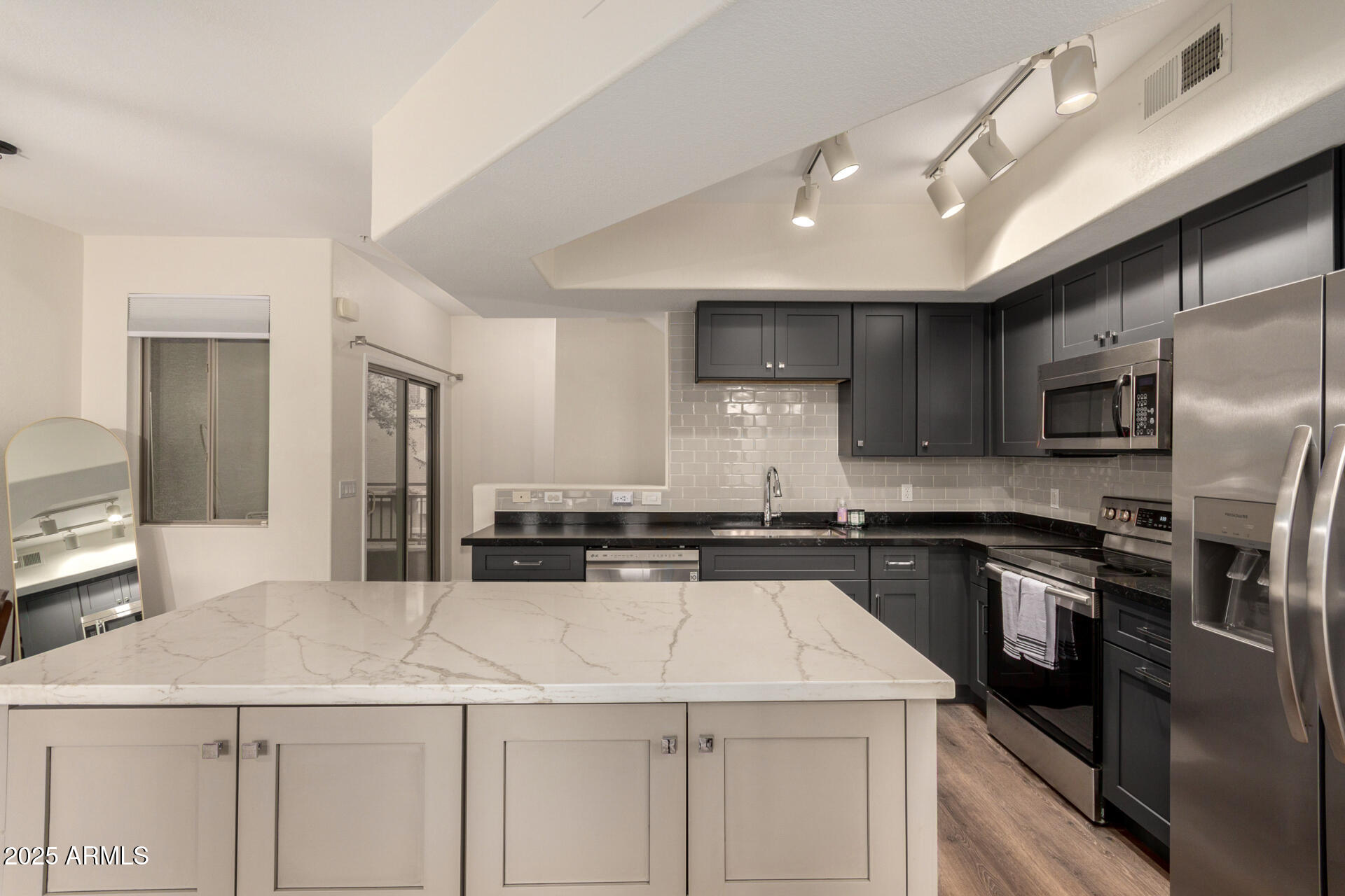 240 West Juniper Avenue, Unit 1010 Gilbert, AZ 85233 - Photo 5 of 46 a kitchen with a sink stainless steel appliances and white cabinets