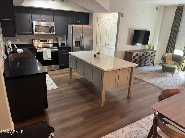 a large kitchen with a table chairs refrigerator and microwave