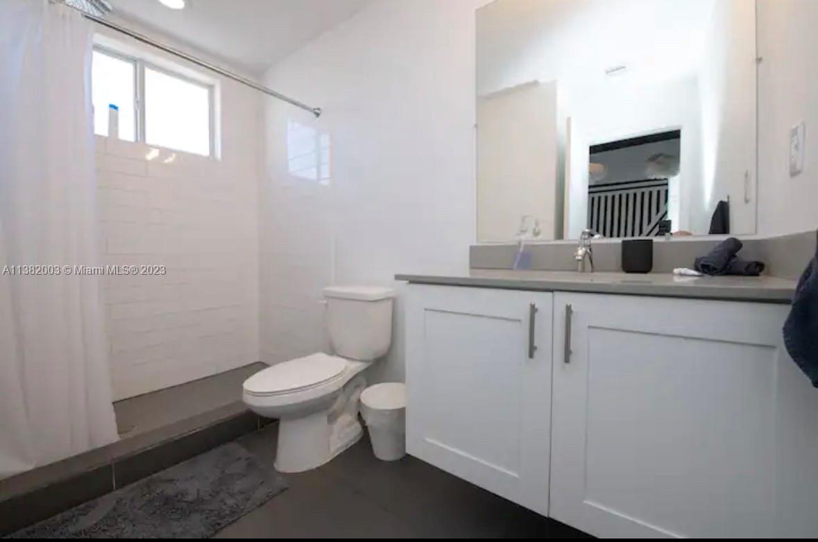 Wynwood Miami, FL 33127 - Photo 11 of 16 a bathroom with a granite countertop toilet sink and mirror