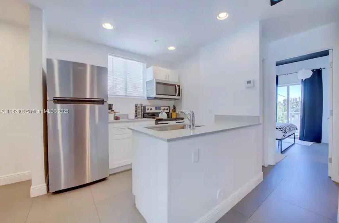 Wynwood Miami, FL 33127 - Photo 5 of 16 a kitchen with stainless steel appliances granite countertop a refrigerator sink and cabinets