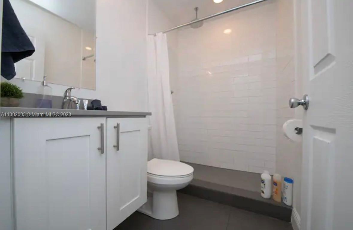 Wynwood Miami, FL 33127 - Photo 10 of 16 a bathroom with a granite countertop sink a toilet and shower