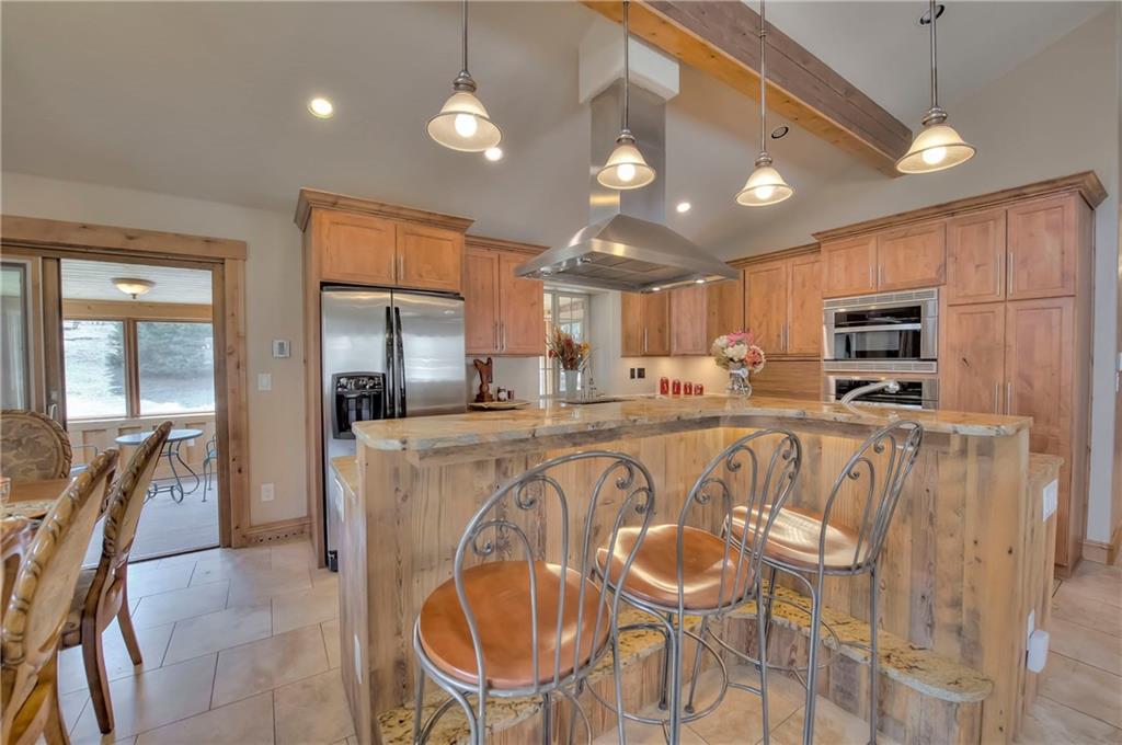 898 Deer Path Road Dillon, CO 80435 - Photo 4 of 34 a kitchen with stainless steel appliances granite countertop a dining table chairs refrigerator and microwave