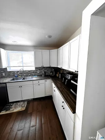 a kitchen with granite countertop stainless steel appliances a stove sink and cabinets
