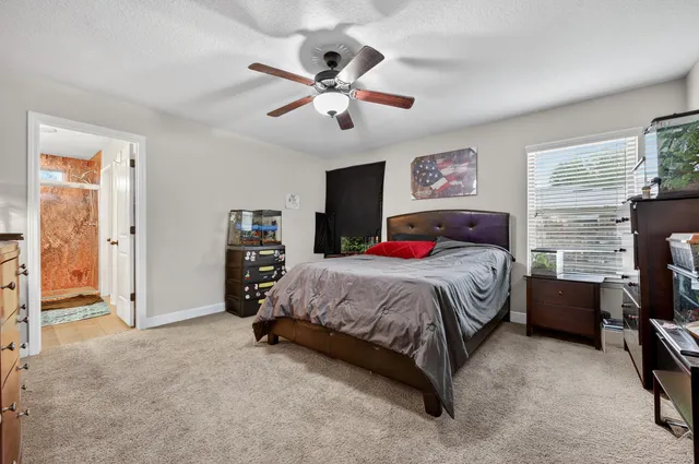 a spacious bedroom with a bed and a chandelier