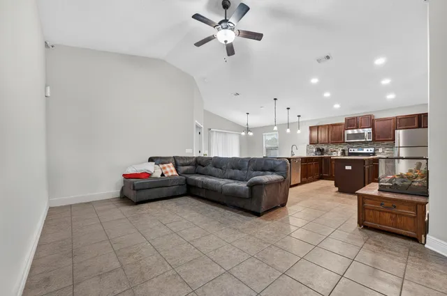 a living room with furniture and kitchen view