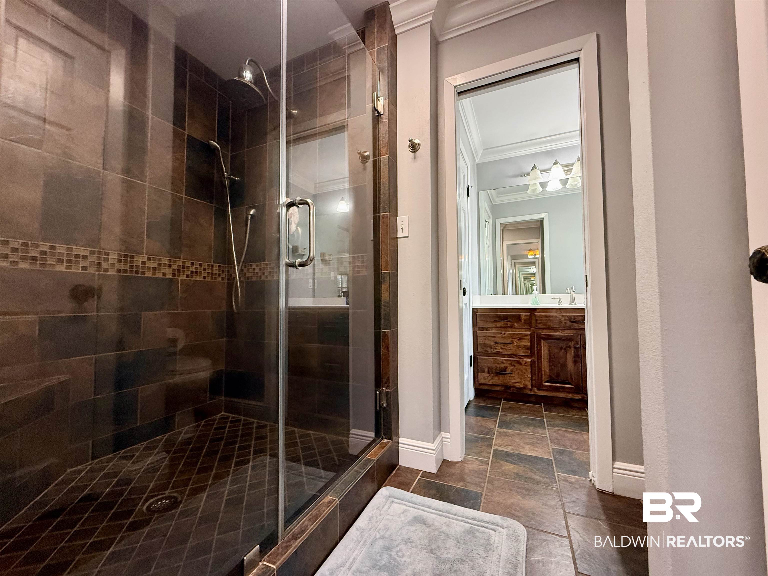 5646 Foshee Road Brewton, AL 36426 - Photo 15 of 37 Full bath featuring ornamental molding, vanity, a shower stall, and stone tile flooring