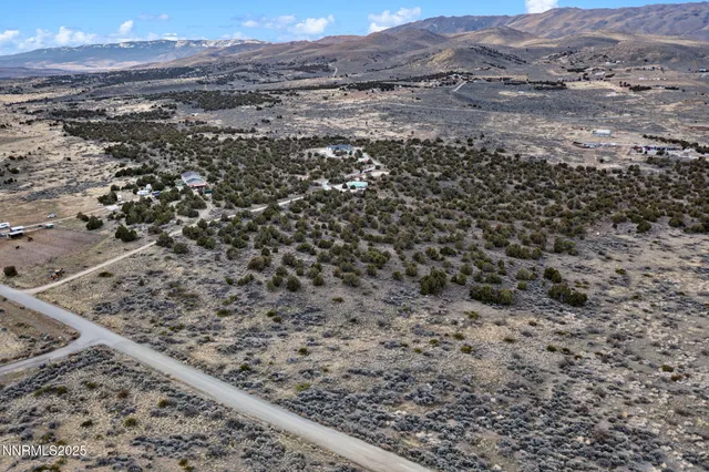 a view of a dry yard with mountains in the background