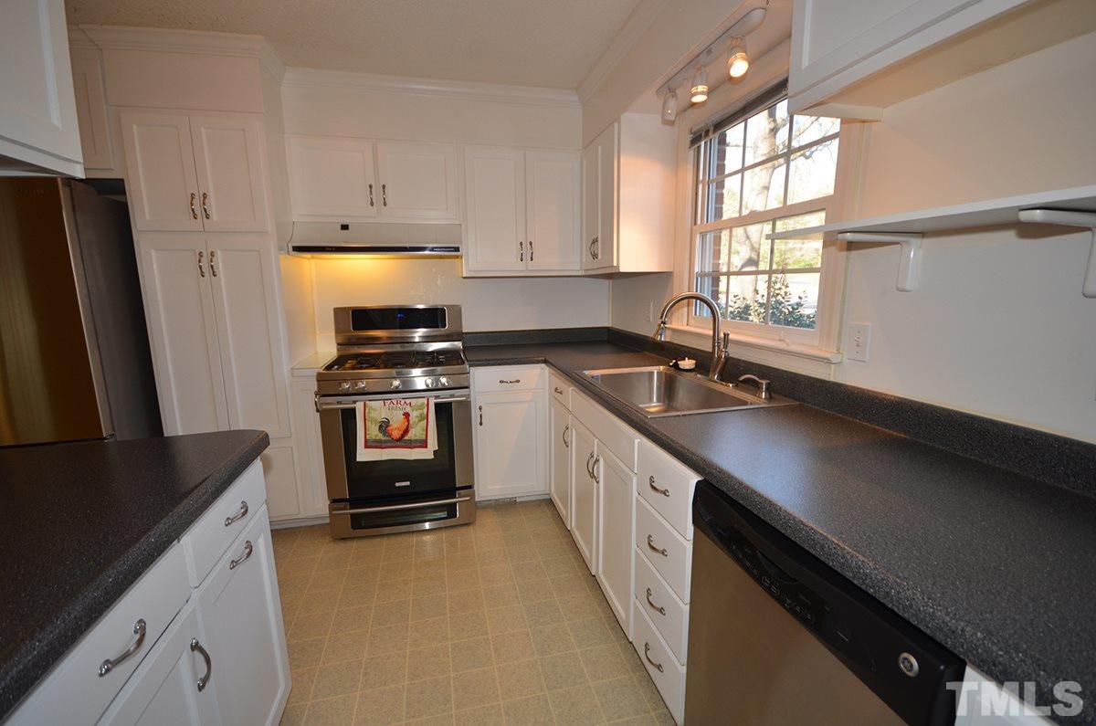 4905 Revere Road Durham, NC 27713 - Photo 11 of 24 a kitchen with granite countertop a sink a stove and refrigerator