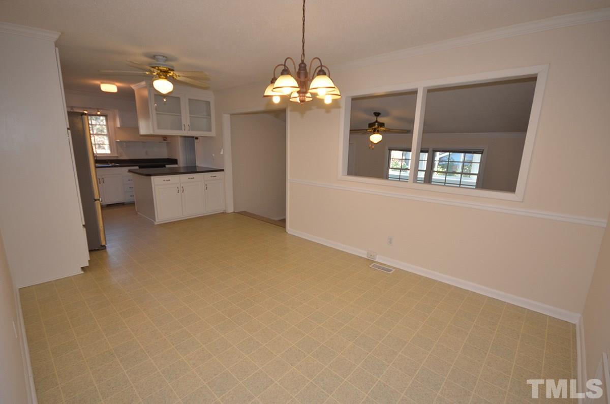4905 Revere Road Durham, NC 27713 - Photo 7 of 24 a kitchen with a refrigerator a sink and a chandelier